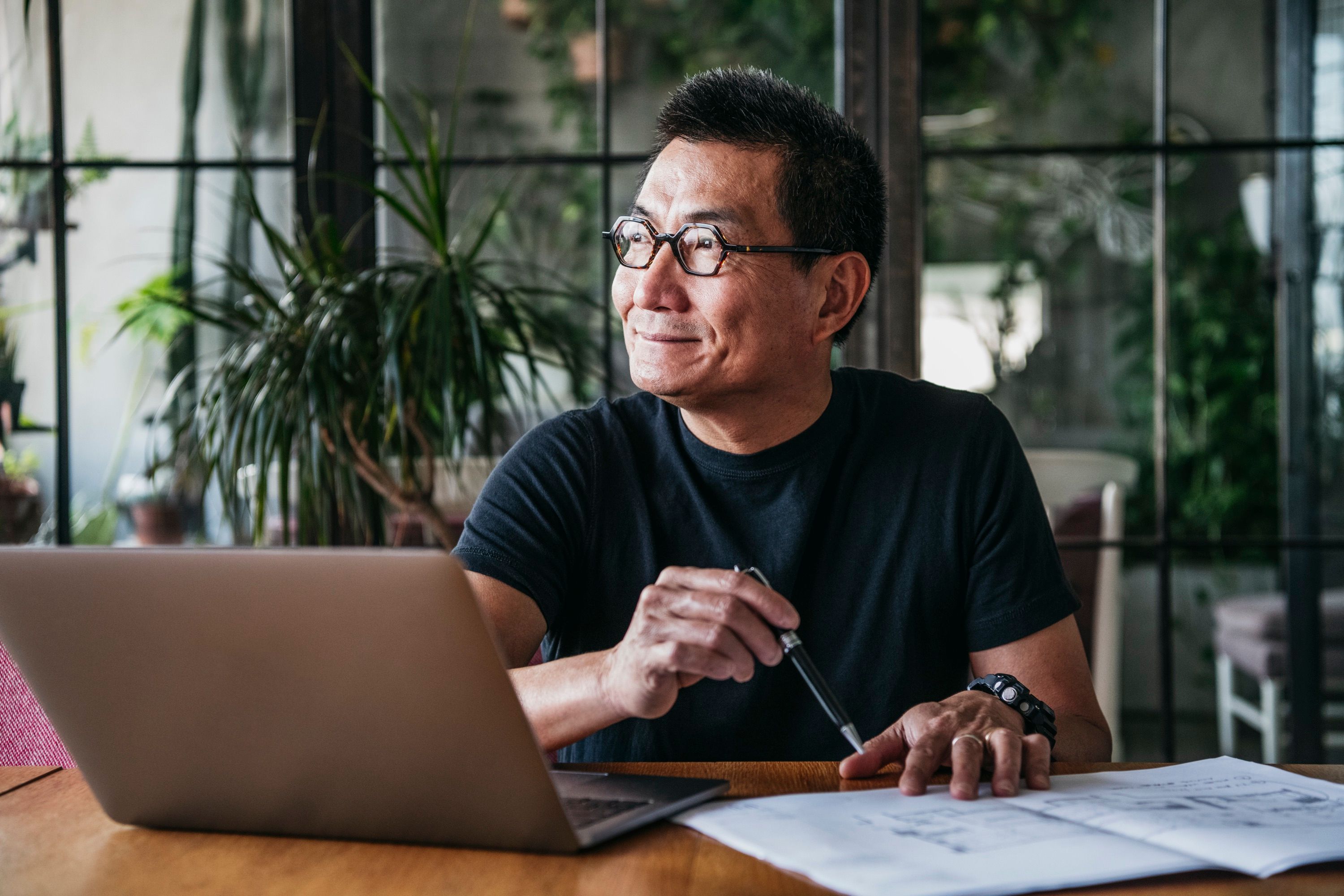 Man smiling while working on a laptop at home
